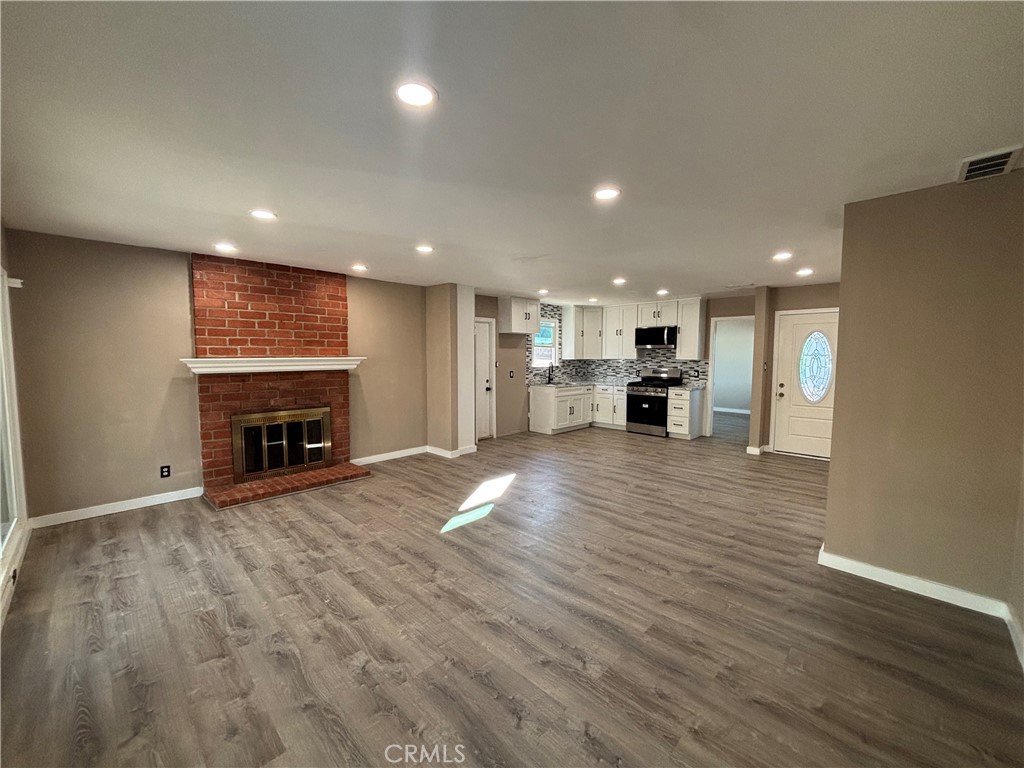 15360 Washington Street Riverside, CA 92506 - Photo 4 of 14 an empty room with wooden floor fireplace and window