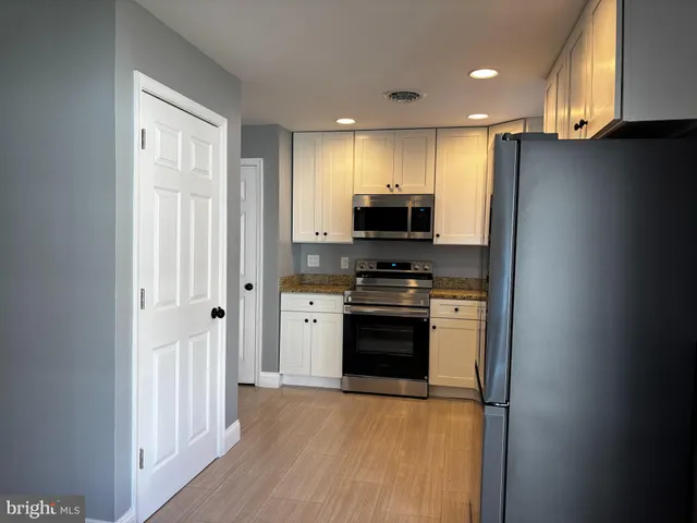 a kitchen with stainless steel appliances a refrigerator stove and microwave