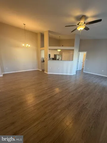 a view of a room with wooden floor fireplace and window