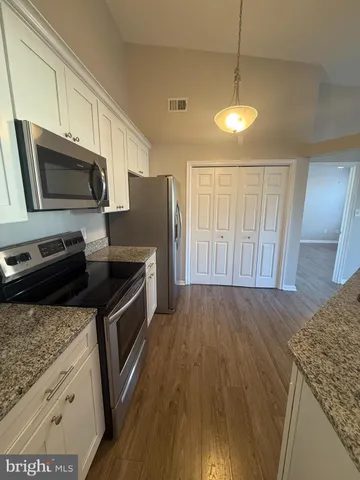 a kitchen with granite countertop a sink a counter top space appliances and cabinets