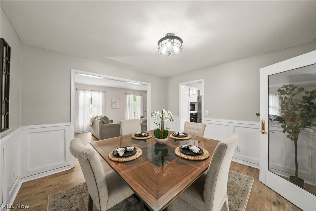dining room with new flooring and wains coting