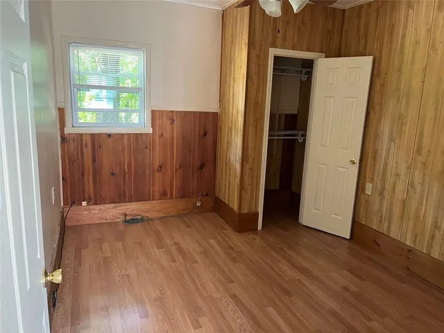 an empty room with wooden floor and a window