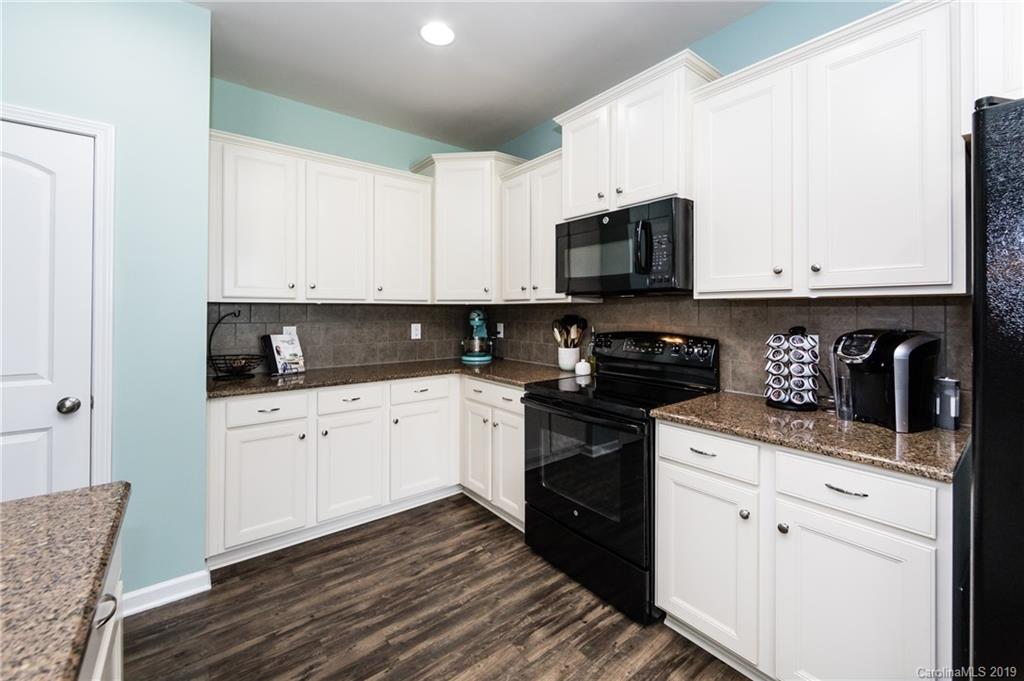 79481 Ridgehaven Road Lancaster, SC 29720 - Photo 15 of 41 a kitchen with stainless steel appliances granite countertop a stove a sink and white cabinets