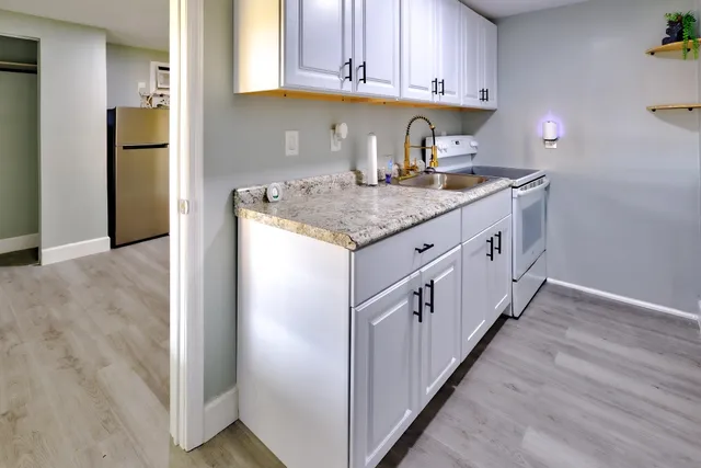 a kitchen with stainless steel appliances granite countertop a sink and a refrigerator