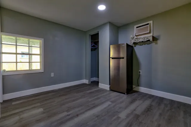 an empty room with wooden floor and closet