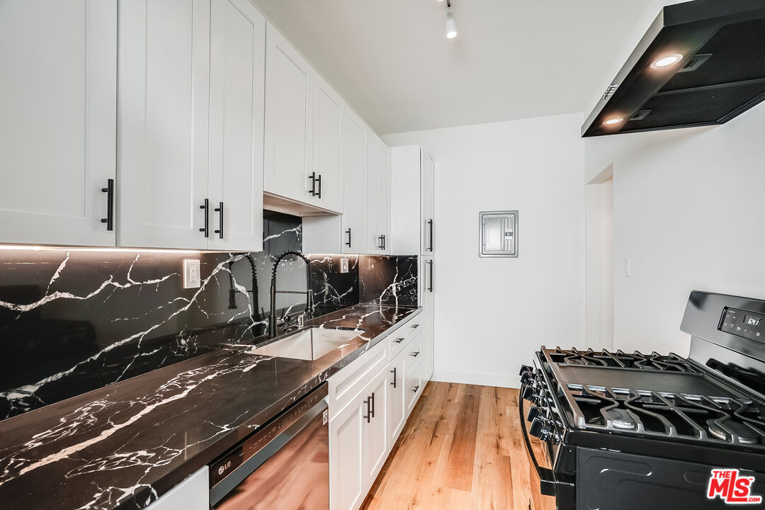 151 North Swall Drive, Unit 4 Beverly Hills, CA 90211 - Photo 11 of 17 a kitchen with granite countertop a stove and a sink