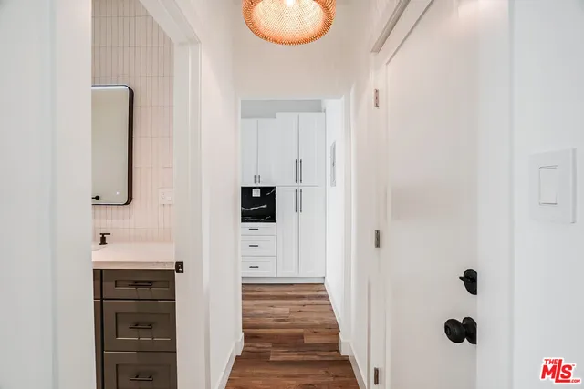 a hallway with cabinets and wooden floor