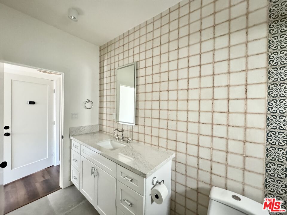 151 North Swall Drive, Unit 4 Beverly Hills, CA 90211 - Photo 8 of 17 a bathroom with a sink mirror vanity and toilet