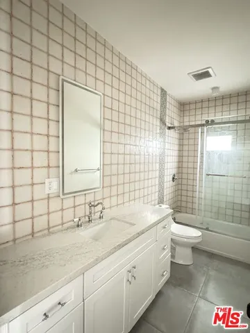 a bathroom with a double vanity sink toilet and shower