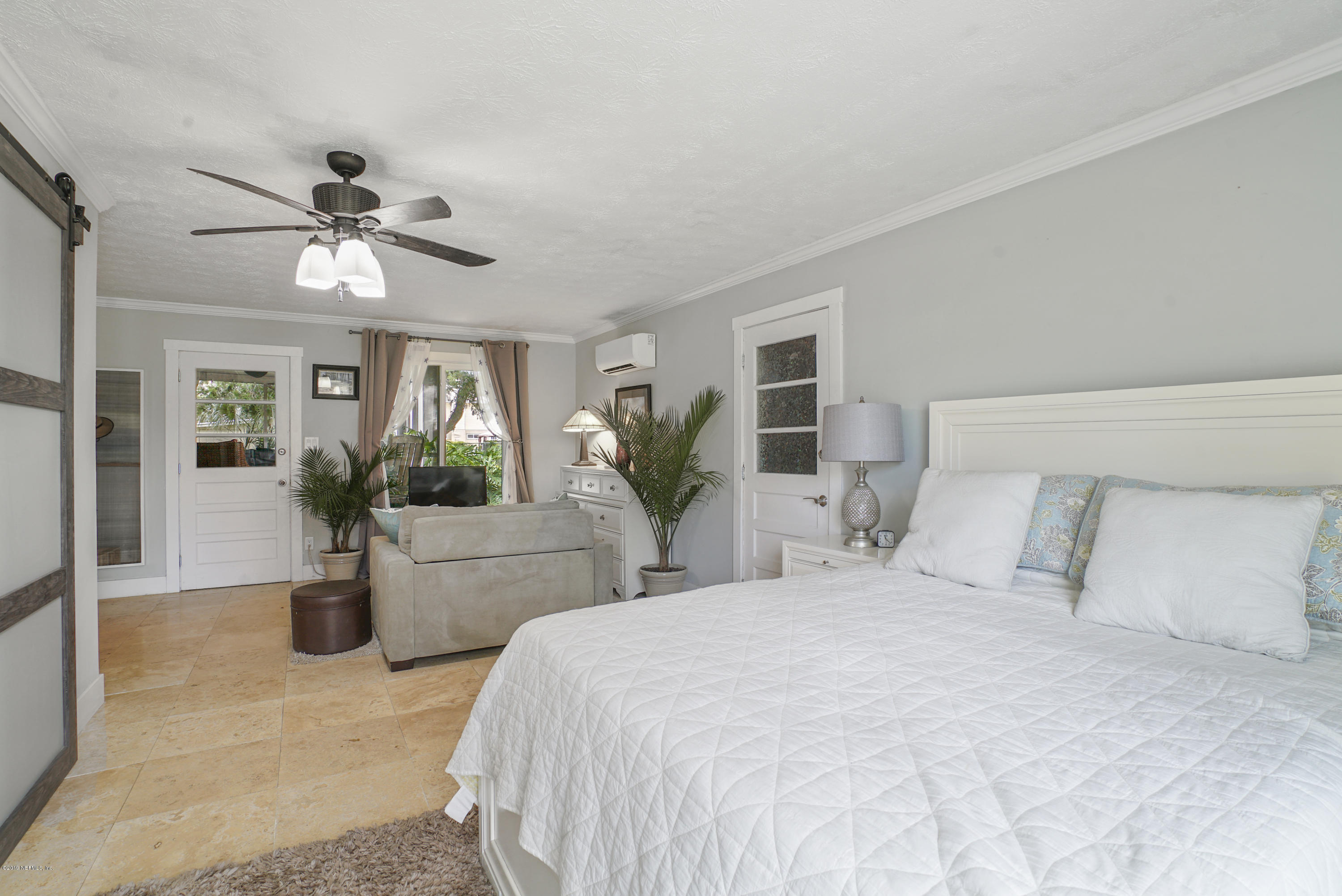 32 Dolphin Drive St. Augustine, FL 32080 - Photo 20 of 43 a bedroom with a balcony a bed and a chandelier