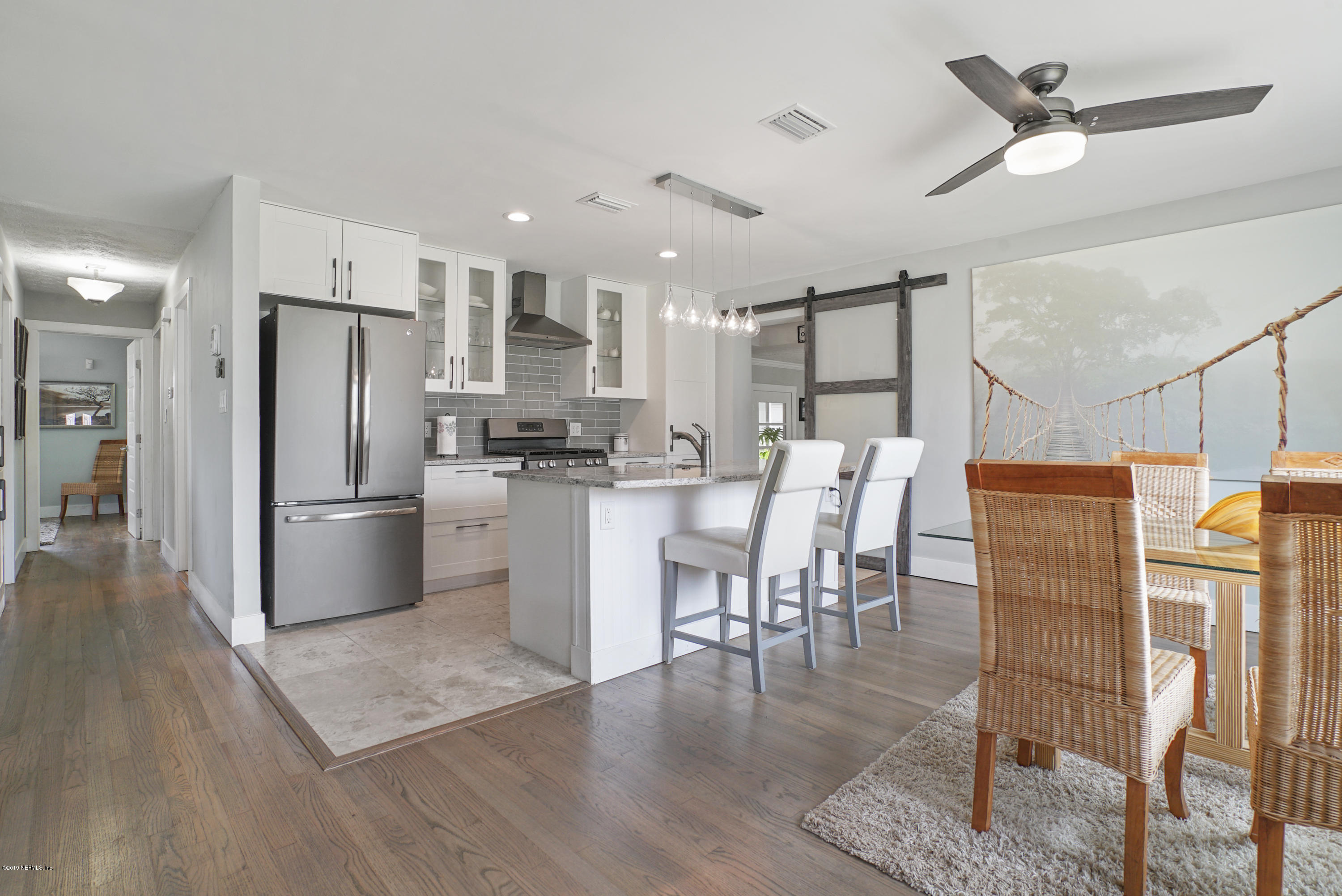32 Dolphin Drive St. Augustine, FL 32080 - Photo 5 of 43 a kitchen with stainless steel appliances kitchen island granite countertop a refrigerator a stove a sink a dining table and chairs with wooden floor