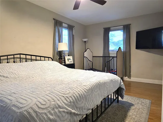 a bedroom with a bed and a flat tv screen on dresser
