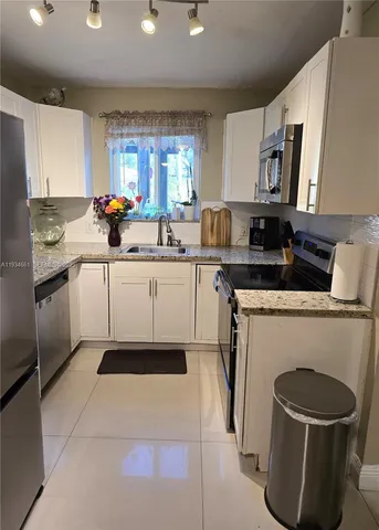 a kitchen with a sink cabinets and appliances