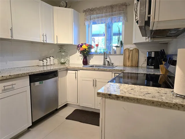a kitchen with stainless steel appliances granite countertop a sink stove and cabinets