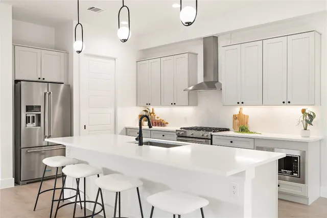 a kitchen with stainless steel appliances a sink stove and refrigerator