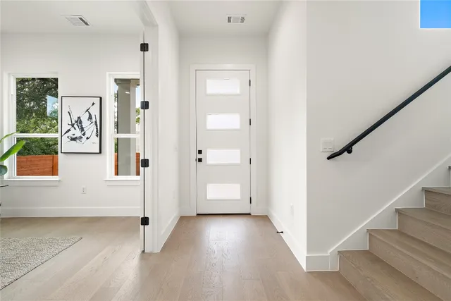 a spacious bedroom with a large bed and a chandelier