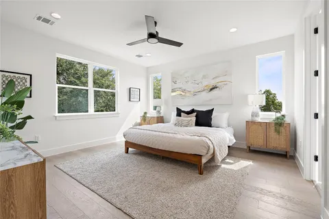 a bedroom with a large bed and a chandelier