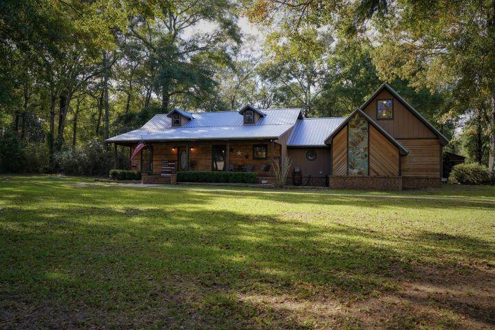 5846 Dairy Road Baker, FL 32531 - Photo 2 of 68 a front view of a house with a garden