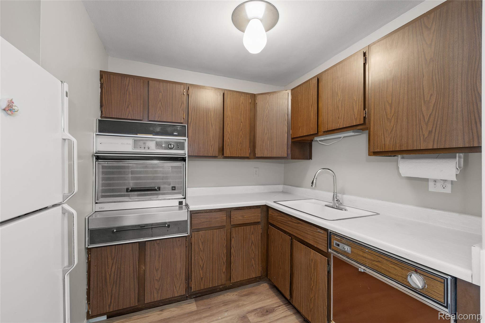 4909 Crooks Road, Unit D6 Royal Oak, MI 48073 - Photo 11 of 16 Kitchen with freestanding refrigerator, light countertops, a warming drawer, oven, and light wood-style floors