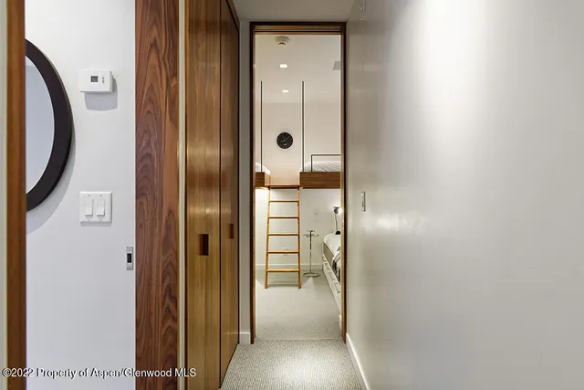 hallway with wooden floor and a bathroom