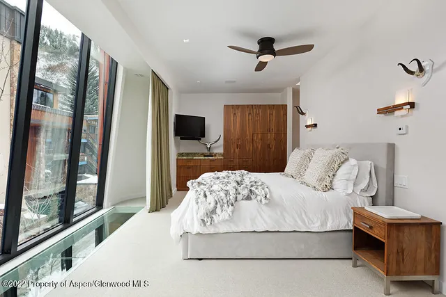 a bedroom with a large bed and a flat tv screen on dresser