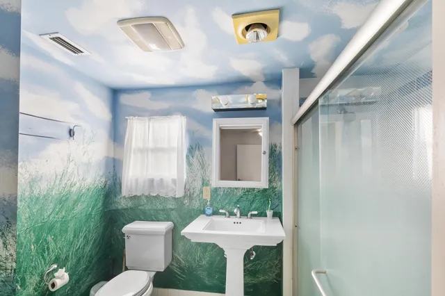 a bathroom with a sink mirror and toilet