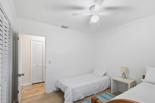a bedroom with a bed and a ceiling fan