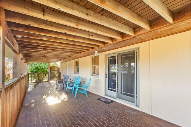 a view of a patio with table and chairs and wooden floor