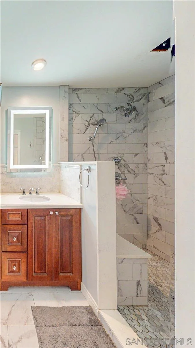 1525 Fair Glen Road El Cajon, CA 92019 - Photo 13 of 15 a bathroom with a granite countertop sink a mirror and shower