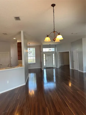 a view of a room with wooden floor and windows