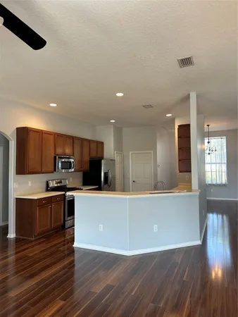a large kitchen with stainless steel appliances and wooden floors