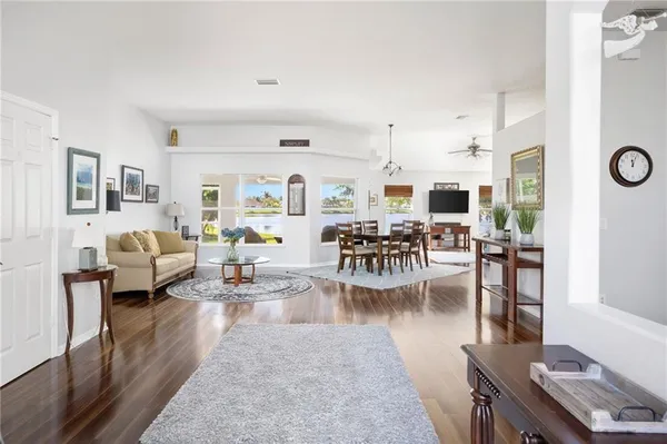 a living room with furniture kitchen view and a window