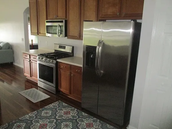 a metallic refrigerator freezer sitting inside of a kitchen