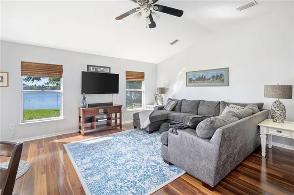 a living room with furniture and a flat screen tv with wooden floor