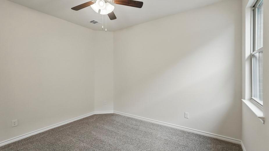 4162 Waldron Trail Forney, TX 75126 - Photo 24 of 29 Neutral painted walls with a window, ceiling fan, and carpeted flooring