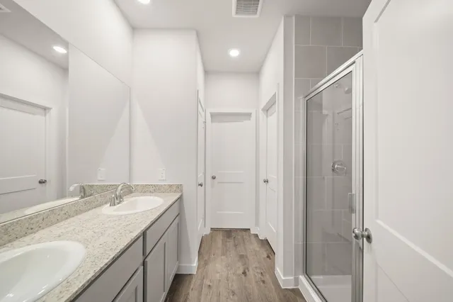 a bathroom with a granite countertop sink a mirror and a shower