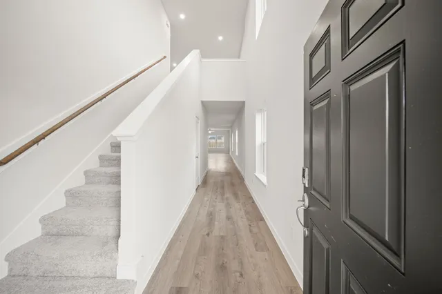 a view of a hallway with wooden floor and staircase