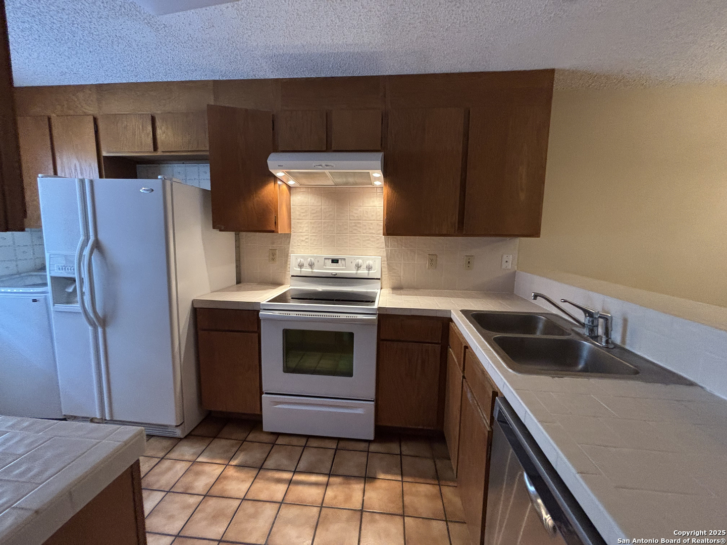 11815 Vance Jackson Road, Unit 1602 San Antonio, TX 78230 - Photo 3 of 24 a kitchen with a sink stove and refrigerator