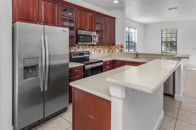 a kitchen with stainless steel appliances a refrigerator sink and microwave