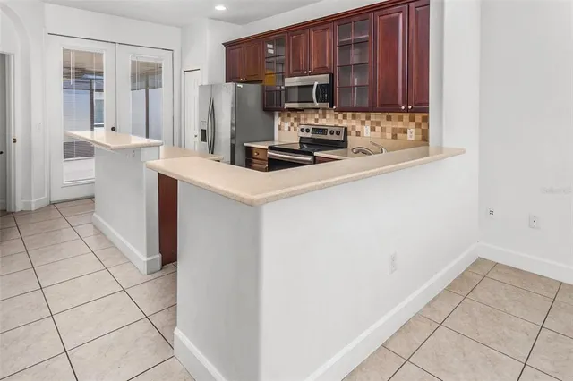 a kitchen with stainless steel appliances a sink a stove a refrigerator a microwave and cabinets