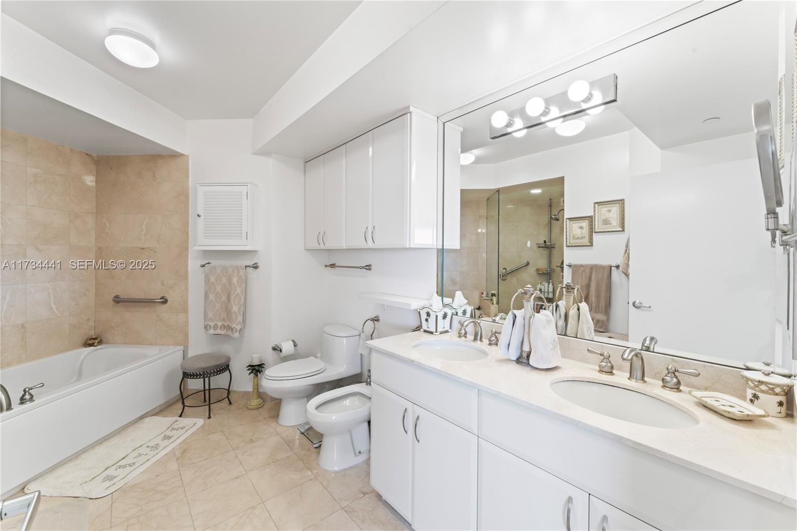 6365 Collins Avenue, Unit 1901 Miami Beach, FL 33141 - Photo 34 of 84 a spacious bathroom with a double vanity sink toilet mirror and bathtub