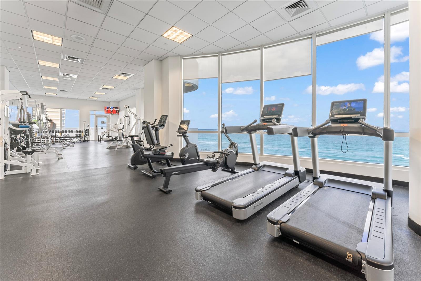 6365 Collins Avenue, Unit 1901 Miami Beach, FL 33141 - Photo 43 of 84 a room with gym equipment and a table