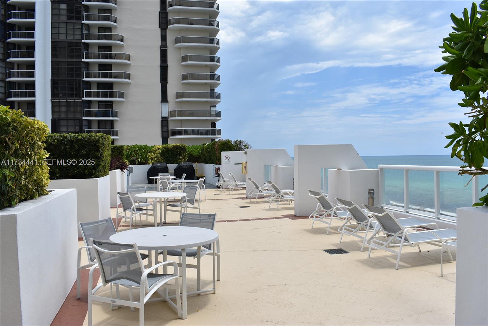 6365 Collins Avenue, Unit 1901 Miami Beach, FL 33141 - Photo 69 of 84 a view of a patio with table and chairs and potted plants
