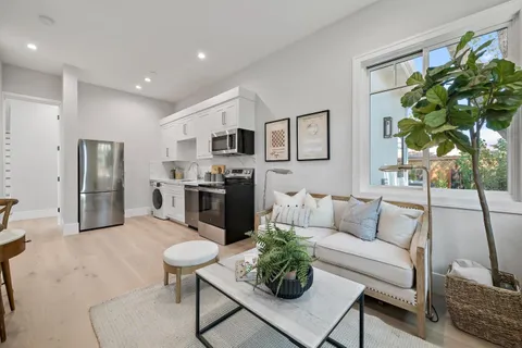 a living room with furniture and a kitchen area