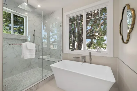 a white bath tub sitting next to a shower