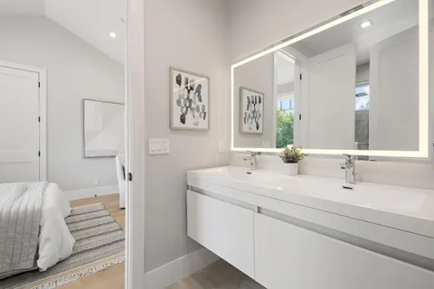 a en suite bathroom with a double vanity sink a mirror and a shower