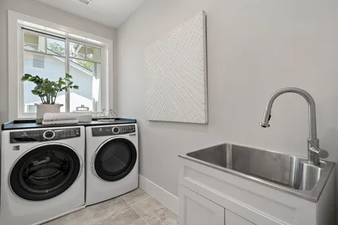 a utility room with sink dryer and washer