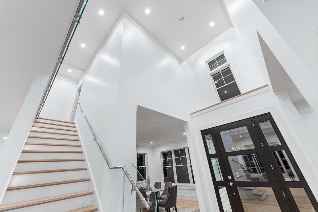 480 Dudley Road Newton, MA 02459 - Photo 11 of 35 a view of staircase with lots of frames on wall and a ceiling fan