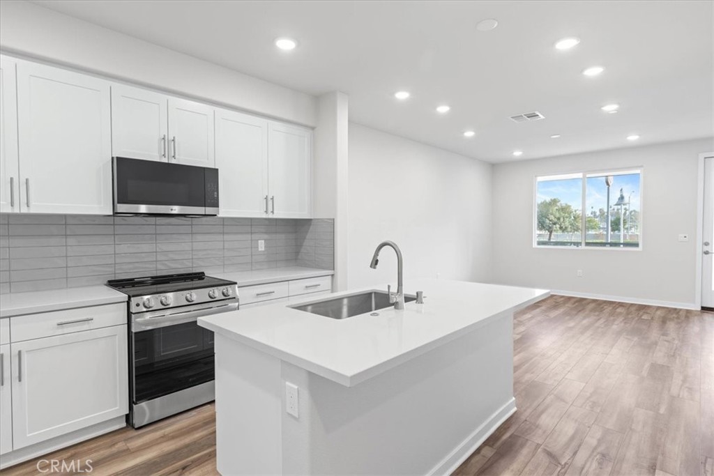9518 Hannah Way Riverside, CA 92503 - Photo 7 of 17 a kitchen with a sink cabinets and wooden floor
