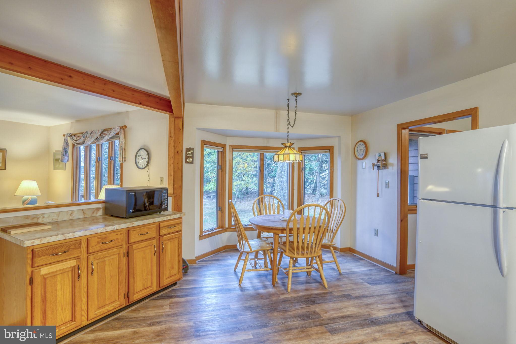 5 Bay Point Road Millsboro, DE 19966 - Photo 36 of 83 a kitchen with a table chairs refrigerator and microwave